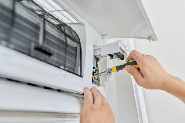 Técnico ajustando una unidad interior de aire acondicionado