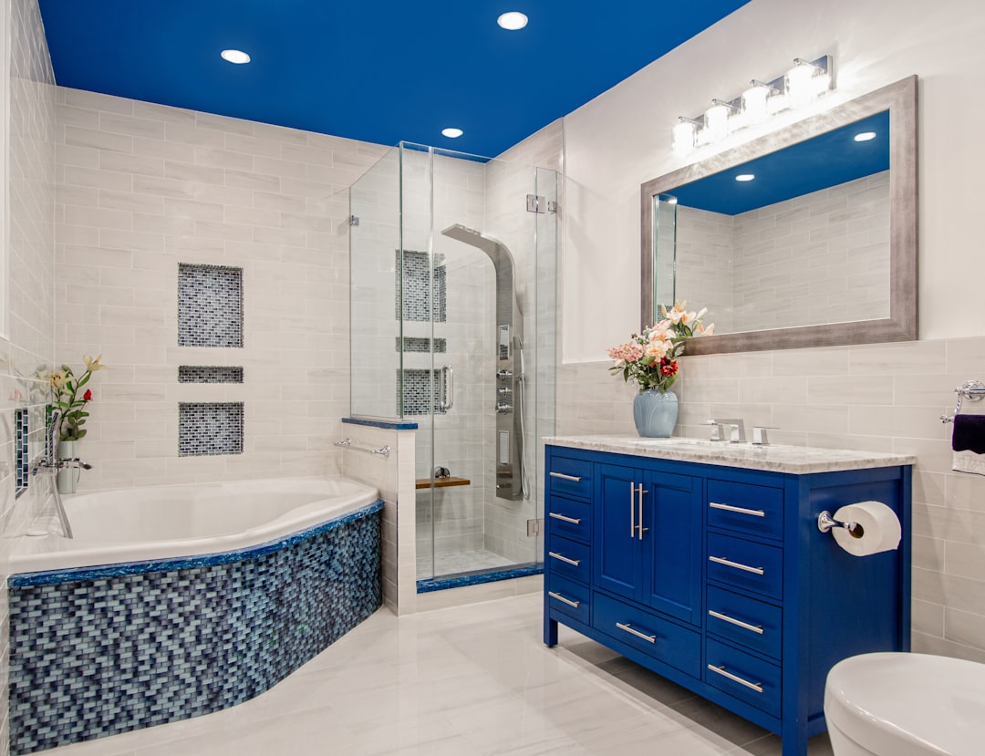 Baño reformado por Reformatta con bañera de mosaico azul y ducha independiente, ideal antes de cambiar bañera por ducha