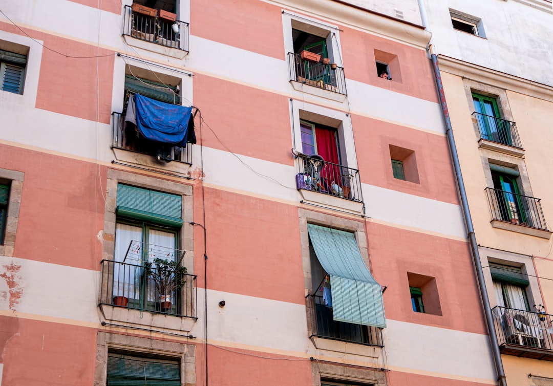 Fachada de piso antiguo en Barcelona con balcones y desperfectos, ideal para una reforma integral con Reformatta