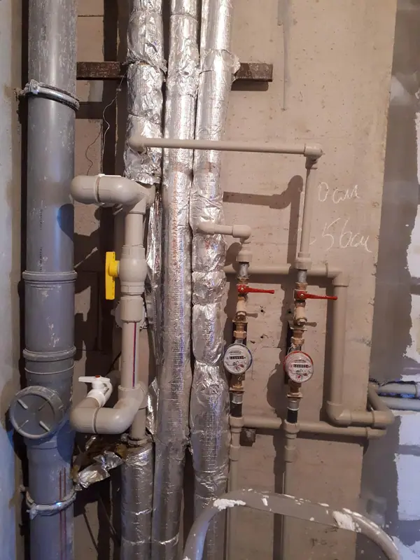 Tuberías, llaves de corte y bajantes en un cuarto de instalaciones